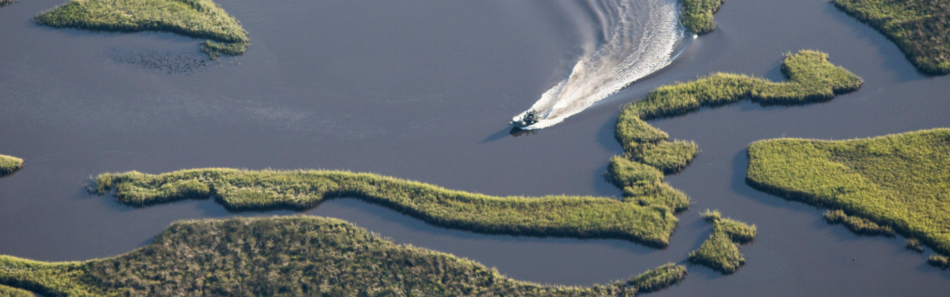 aerial image of a boat cruising through cedar key florida